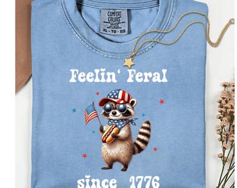 Camiseta patriótica de mapache Comfort Colors, camiseta de mapache salvaje 1776, camiseta del cumpleaños de América, camiseta unisex de tejido grueso teñida en prenda.