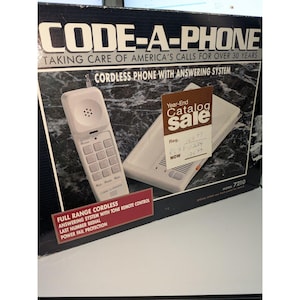 May include: A Code-A-Phone cordless phone with answering system in its original box. The packaging features the text Code-A-Phone, Taking Care of America's Calls for Over 30 Years, and Model 7210. A brown sale tag is attached to the front of the box.