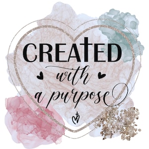 May include: A heart-shaped design with a glittery gold border and a watercolor background in shades of pink, blue, and gold. The text "CREATED with a purpose" is written in black inside the heart.