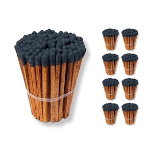 May include: A bundle of long wooden matches with dark gray tips, bound together with a clear rubber band. Several smaller bundles of matches are also shown, each with a similar design.