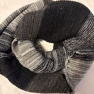 May include: A black and white striped infinity scarf made of soft knit fabric.