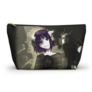 May include: A black and green zippered pouch with a graphic print of a purple-haired character with horns and a striped shirt. The character is standing in front of a shadowy figure with horns.