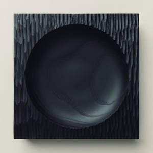 May include: A square black wooden bowl with a smooth, circular interior basin and a deeply textured, carved exterior surface. The wood grain is visible within the dark finish, and the edges of the square frame contrast with the round centre.