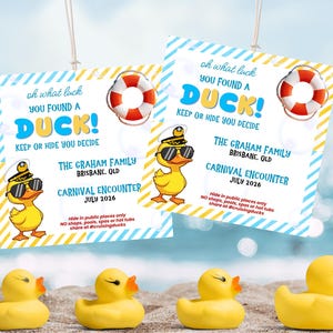May include: Two blue and white tags with the text "oh what luck YOU FOUND A DUCK!" and a cartoon duck wearing sunglasses. Four yellow rubber ducks are in the foreground. The tags also say "Keep or Hide You Decide".