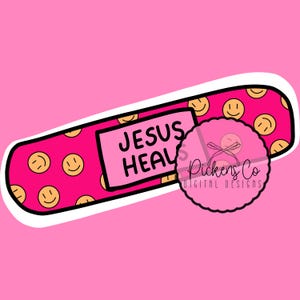 Puede incluir: Una tirita rosa y blanca con un patrón de caritas sonrientes y el texto "JESUS HEALS" en negro. La tirita es un diseño digital.