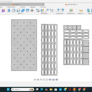 May include: A computer screen shows a CAD design for an "Autt Fab Table v1". The design features several grey, rectangular components with various patterns of holes and slots, probably for assembly. The screen displays the design in a 2D view.