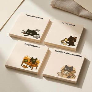 Puede incluir: Cuatro blocs de notas adhesivas cuadrados de color crema con ilustraciones de gatos negros y texto. Las notas dicen: Motivation not found, Too cute to work, Everything is fine y Currently avoiding everything, con varios gráficos de gatos.