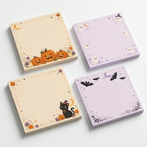 Könnte beinhalten: Vier quadratische Haftnotizblöcke mit Halloween-Motiven. Zwei Blöcke sind cremefarben mit orangefarbenen Kürbissen und einer schwarzen Katze mit violettem Hut. Zwei Blöcke sind hellviolett mit weißen Geistern und schwarzen Fledermäusen.