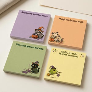 May include: Four square sticky note pads in purple, orange, green, and yellow. The purple pad says Suspiciously important things: with a raccoon in a witch hat. The orange pad says Things I'm dying to avoid: with a mummy opossum. The green pad says Tiny catastrophes to deal with: with a black cat. The yellow pad says Spells, errands & other nonsense: with a frog on a broom.