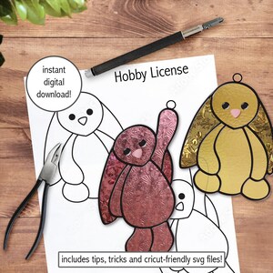 May include: A sheet with bunny outline drawings, a pair of pliers, and a stained glass bunny ornament. The text "instant digital download!" and "Hobby License" are visible. The image is on a wooden surface.