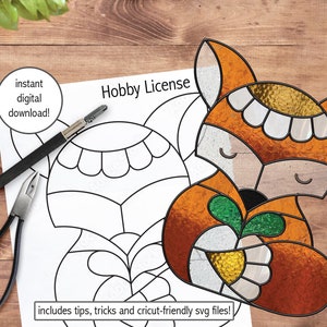 Puede incluir: Una descarga digital de un patrón de vitral para un zorro sosteniendo una zanahoria. El patrón está delineado en negro e incluye una guía de colores. El texto "Hobby License" y "includes tips, tricks and cricut-friendly svg files!" también está incluido.
