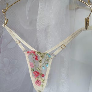 May include: White sheer lingerie with floral embroidery in pink, red, blue, and green.