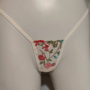 May include: White lace underwear with a floral embroidery design in shades of pink, red, blue, and green.
