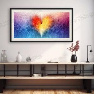 Puede incluir: Una impresión de arte abstracto enmarcada con una forma de corazón colorida en el centro. El corazón está formado por muchos cuadrados pequeños en tonos de azul, morado, rojo, naranja y amarillo. El fondo es un degradado de morado claro y azul.