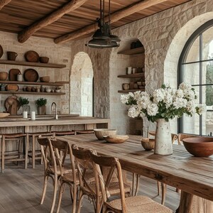 May include: A rustic dining room with a large wooden table and chairs. The room has a stone wall with arched windows and a wooden ceiling. There are plants and a vase on the table.
