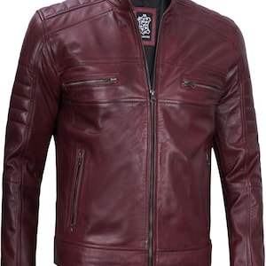 May include: A burgundy leather motorcycle jacket with a zipper closure and multiple pockets. The jacket has a quilted design on the shoulders and a stand-up collar.