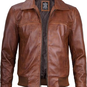 May include: A brown leather bomber jacket with a zipper closure and ribbed knit cuffs and waistband. The jacket has a small label on the inside that says "Real Leather".