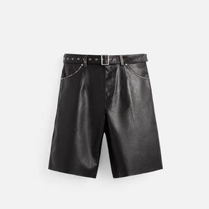 May include: Black leather shorts with a belt. The shorts have a high waist, a belt with a silver buckle, and pockets. The shorts are knee-length and made of a smooth, shiny material.
