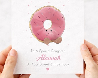 May include: A greeting card with a pink frosted donut illustration. The card reads "To A Special Daughter Alannah On Your Sweet 5th Birthday". The text "Personalise with any name & age" is at the top.