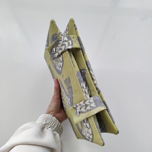 K&ouml;nnte beinhalten: Eine gr&uuml;ne und graue Stofftasche mit Vogelmuster. Die Tasche hat zwei Henkel und einen Rei&szlig;verschluss.