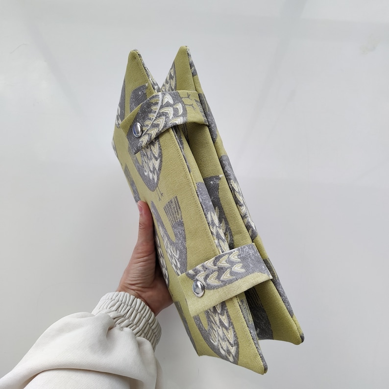 K&ouml;nnte beinhalten: Eine gr&uuml;ne und graue Stofftasche mit Vogelmuster. Die Tasche hat zwei Henkel und einen Rei&szlig;verschluss.
