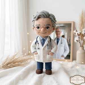 May include: A crocheted doll of a doctor wearing a white coat, blue pants, and brown shoes. The doll has gray hair, glasses, and a stethoscope. A mirror in the background reflects a real doctor. The doll has a name tag that reads "Dr. T. Miller".