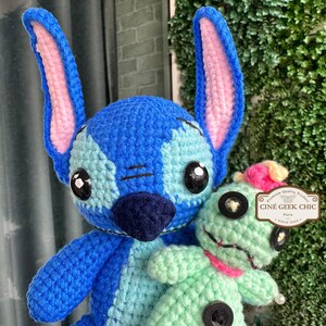 Bring home a fan-favorite duo with this handmade crochet Stitch and Scrump-inspired doll set! Carefully handcrafted with love and soft acrylic yarn, this adorable pair captures the charm of everyone's favorite blue alien and his stitched-up bestie.

Perfect as a collectible, a heartfelt gift for a Stitch lover, or a whimsical piece of decor. Each doll is crafted with attention to detail, from Stitch's signature big ears to Scrump’s button eye and sweet expression. Experiment 626 !