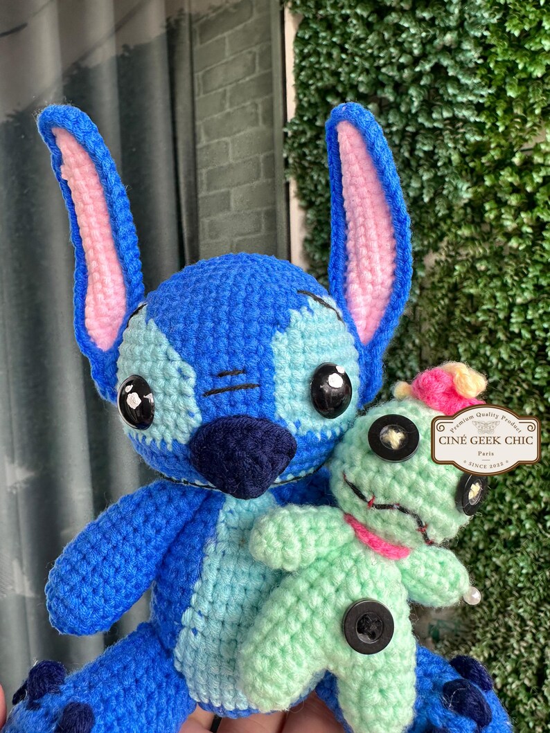 Bring home a fan-favorite duo with this handmade crochet Stitch and Scrump-inspired doll set! Carefully handcrafted with love and soft acrylic yarn, this adorable pair captures the charm of everyone's favorite blue alien and his stitched-up bestie.

Perfect as a collectible, a heartfelt gift for a Stitch lover, or a whimsical piece of decor. Each doll is crafted with attention to detail, from Stitch's signature big ears to Scrump’s button eye and sweet expression. Experiment 626 !
