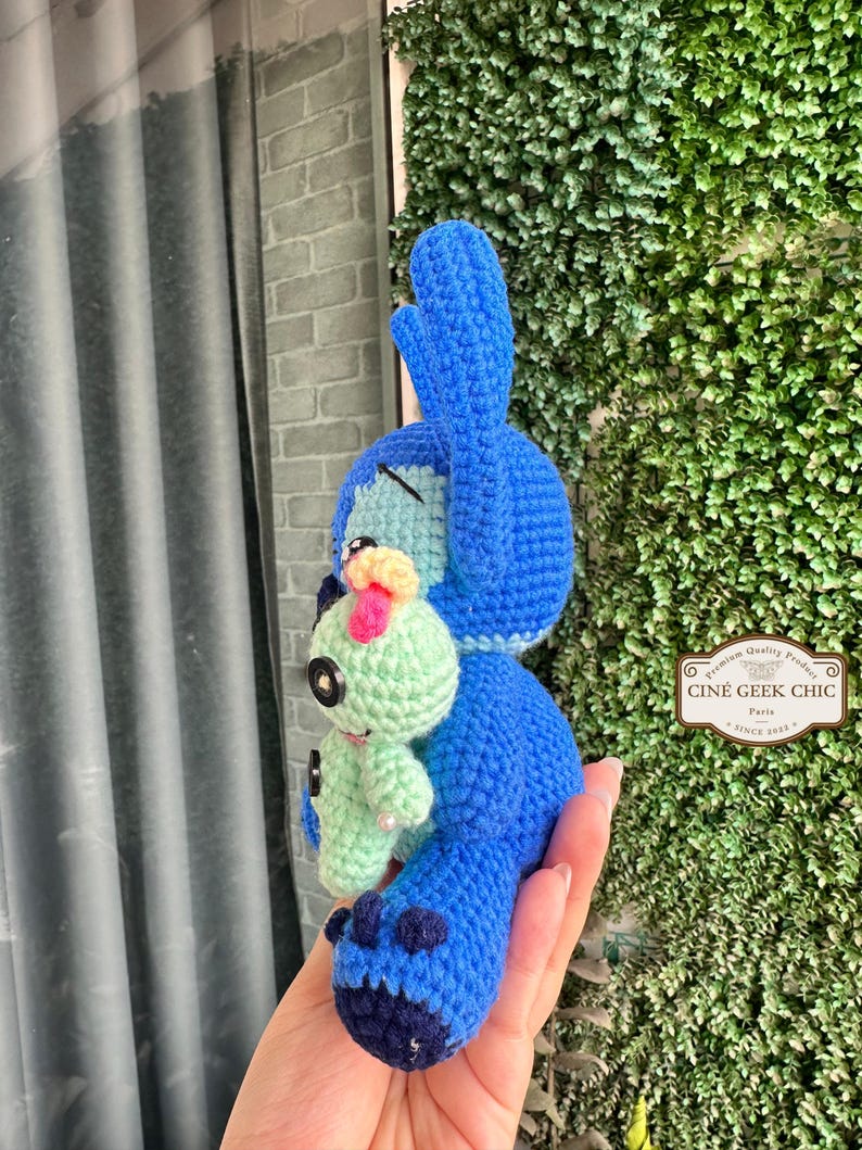 Bring home a fan-favorite duo with this handmade crochet Stitch and Scrump-inspired doll set! Carefully handcrafted with love and soft acrylic yarn, this adorable pair captures the charm of everyone's favorite blue alien and his stitched-up bestie.

Perfect as a collectible, a heartfelt gift for a Stitch lover, or a whimsical piece of decor. Each doll is crafted with attention to detail, from Stitch's signature big ears to Scrump’s button eye and sweet expression. Experiment 626 !
