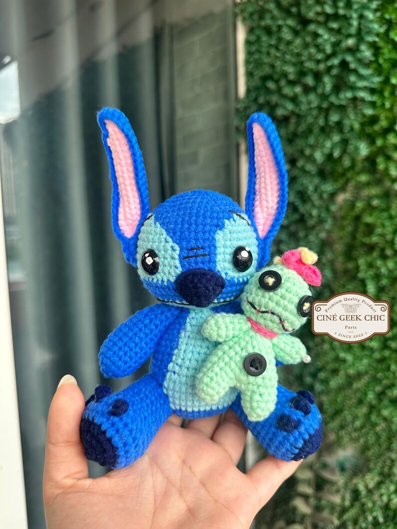 Bring home a fan-favorite duo with this handmade crochet Stitch and Scrump-inspired doll set! Carefully handcrafted with love and soft acrylic yarn, this adorable pair captures the charm of everyone's favorite blue alien and his stitched-up bestie.

Perfect as a collectible, a heartfelt gift for a Stitch lover, or a whimsical piece of decor. Each doll is crafted with attention to detail, from Stitch's signature big ears to Scrump’s button eye and sweet expression. Experiment 626 !