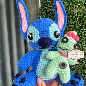 Bring home a fan-favorite duo with this handmade crochet Stitch and Scrump-inspired doll set! Carefully handcrafted with love and soft acrylic yarn, this adorable pair captures the charm of everyone's favorite blue alien and his stitched-up bestie.

Perfect as a collectible, a heartfelt gift for a Stitch lover, or a whimsical piece of decor. Each doll is crafted with attention to detail, from Stitch's signature big ears to Scrump’s button eye and sweet expression. Experiment 626 !