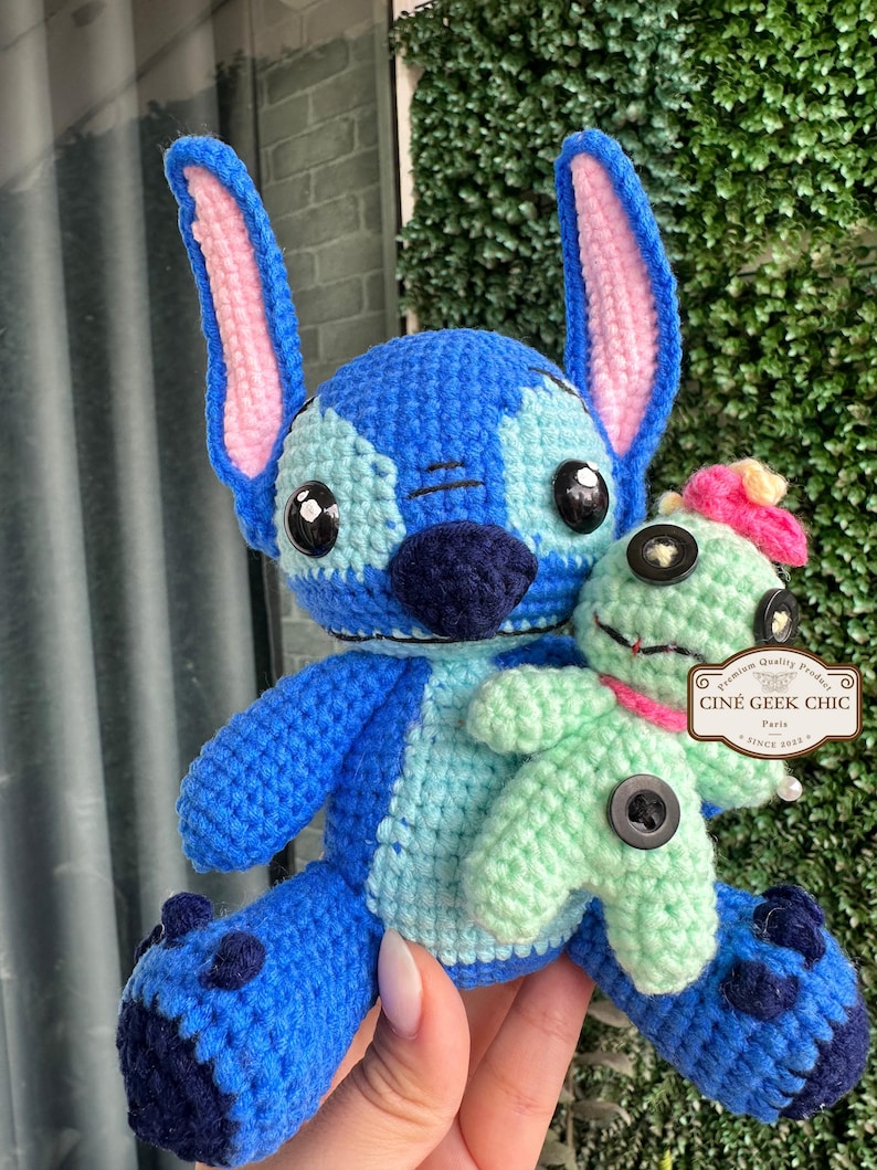 Bring home a fan-favorite duo with this handmade crochet Stitch and Scrump-inspired doll set! Carefully handcrafted with love and soft acrylic yarn, this adorable pair captures the charm of everyone's favorite blue alien and his stitched-up bestie.

Perfect as a collectible, a heartfelt gift for a Stitch lover, or a whimsical piece of decor. Each doll is crafted with attention to detail, from Stitch's signature big ears to Scrump’s button eye and sweet expression. Experiment 626 !