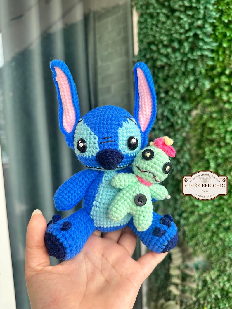Bring home a fan-favorite duo with this handmade crochet Stitch and Scrump-inspired doll set! Carefully handcrafted with love and soft acrylic yarn, this adorable pair captures the charm of everyone's favorite blue alien and his stitched-up bestie.

Perfect as a collectible, a heartfelt gift for a Stitch lover, or a whimsical piece of decor. Each doll is crafted with attention to detail, from Stitch's signature big ears to Scrump’s button eye and sweet expression. Experiment 626 !