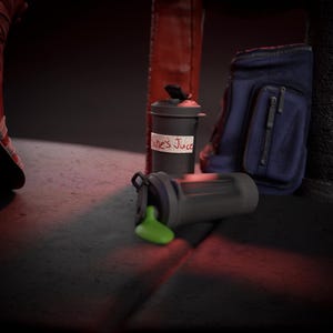 May include: A black and grey shaker bottle with green liquid spilled out, next to a matching shaker bottle with a label that reads "Jane's Juice". A blue gym bag is in the background.