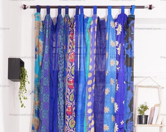 May include: A set of vertical fabric curtain panels hanging from a rod, featuring a patchwork of blue, teal, and purple textiles with various patterns including floral, geometric, and polka dot designs, finished with blue fabric tab tops.