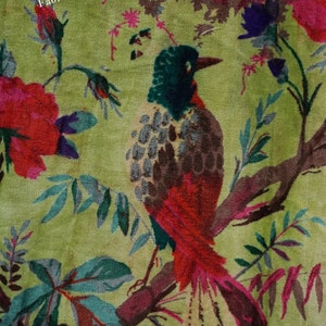 May include: A green velvet fabric with a floral pattern featuring red, pink, and purple flowers, green leaves, and a brown and red bird with a long tail.