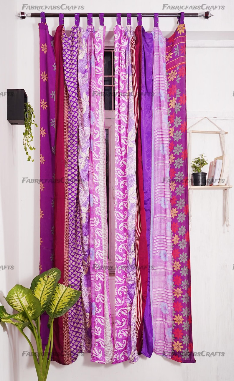 Puede incluir: Un conjunto de siete cortinas largas y coloridas hechas de saris reutilizados. Las cortinas son una mezcla de rosa, morado y blanco con patrones florales y paisley. Las cortinas est&aacute;n colgadas de una barra y est&aacute;n listas para agregar un toque de estilo bohemio a cualquier habitaci&oacute;n.