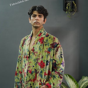 May include: A green velvet robe with a floral and bird print. The robe has a shawl collar and a tie belt.