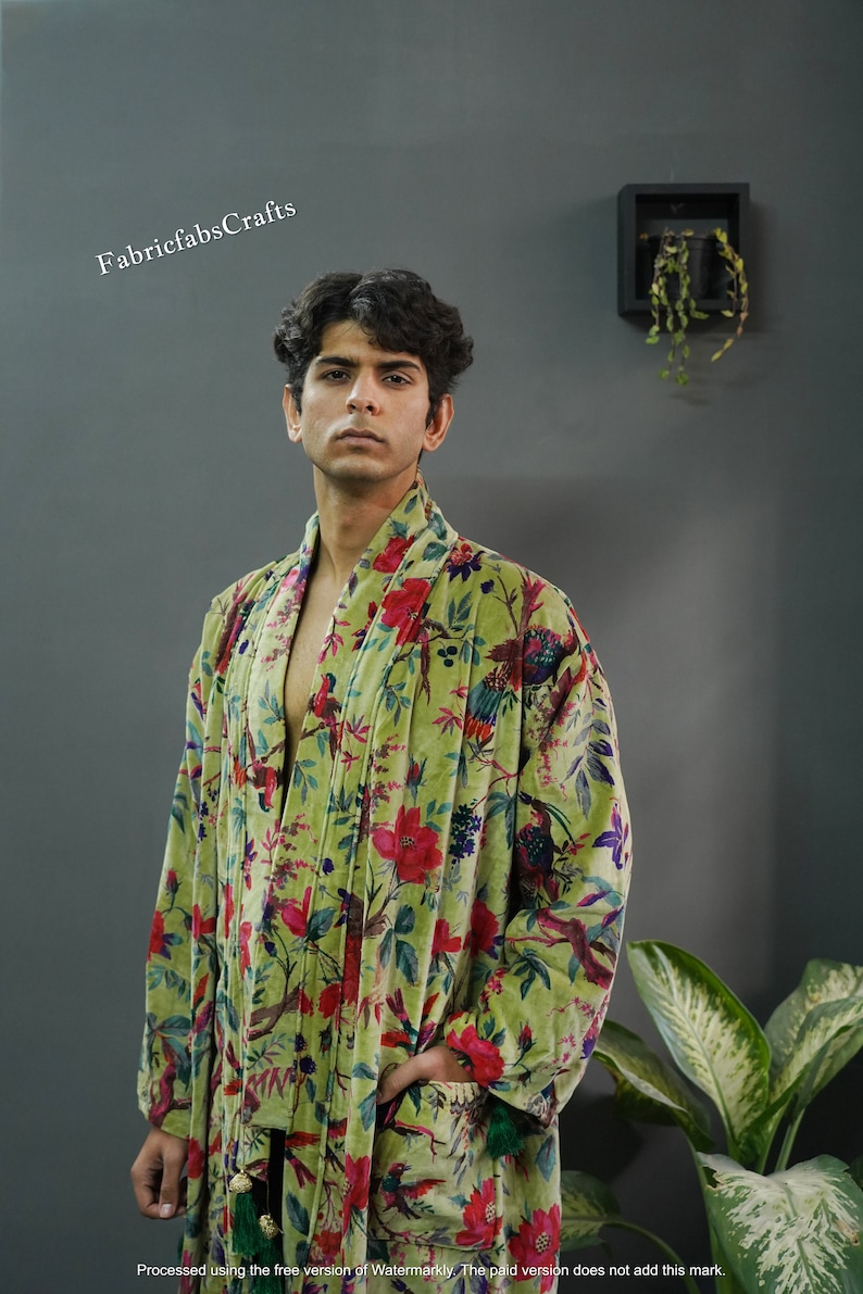 May include: A green velvet robe with a floral and bird print. The robe has a shawl collar and a tie belt.