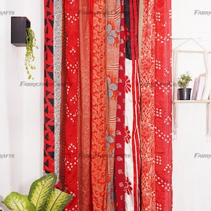 Puede incluir: Cortinas de tela con estampado rojo, naranja y blanco colgadas de una barra de cortina. Las cortinas est&aacute;n hechas de un mosaico de diferentes telas y est&aacute;n atadas con borlas.