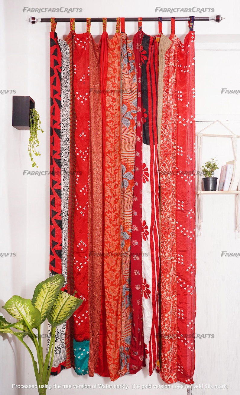 Puede incluir: Cortinas de tela con estampado rojo, naranja y blanco colgadas de una barra de cortina. Las cortinas est&aacute;n hechas de un mosaico de diferentes telas y est&aacute;n atadas con borlas.