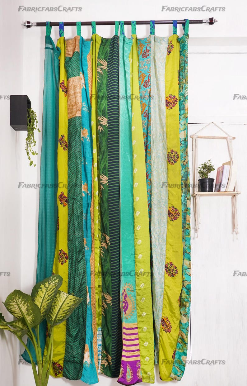 Puede incluir: Un conjunto de cortinas de patchwork verde y azul hechas de saris reciclados. Las cortinas est&aacute;n colgadas de una barra y est&aacute;n compuestas por diferentes piezas de tela cosidas juntas. La tela es una mezcla de seda y algod&oacute;n y tiene una variedad de patrones y colores.