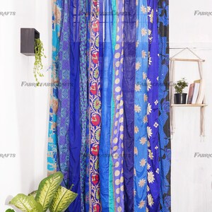 Puede incluir: Un conjunto de cortinas de tela con estampado azul y turquesa que cuelgan de una barra de cortina. Las cortinas est&aacute;n hechas de saris reciclados y tienen un estilo bohemio.