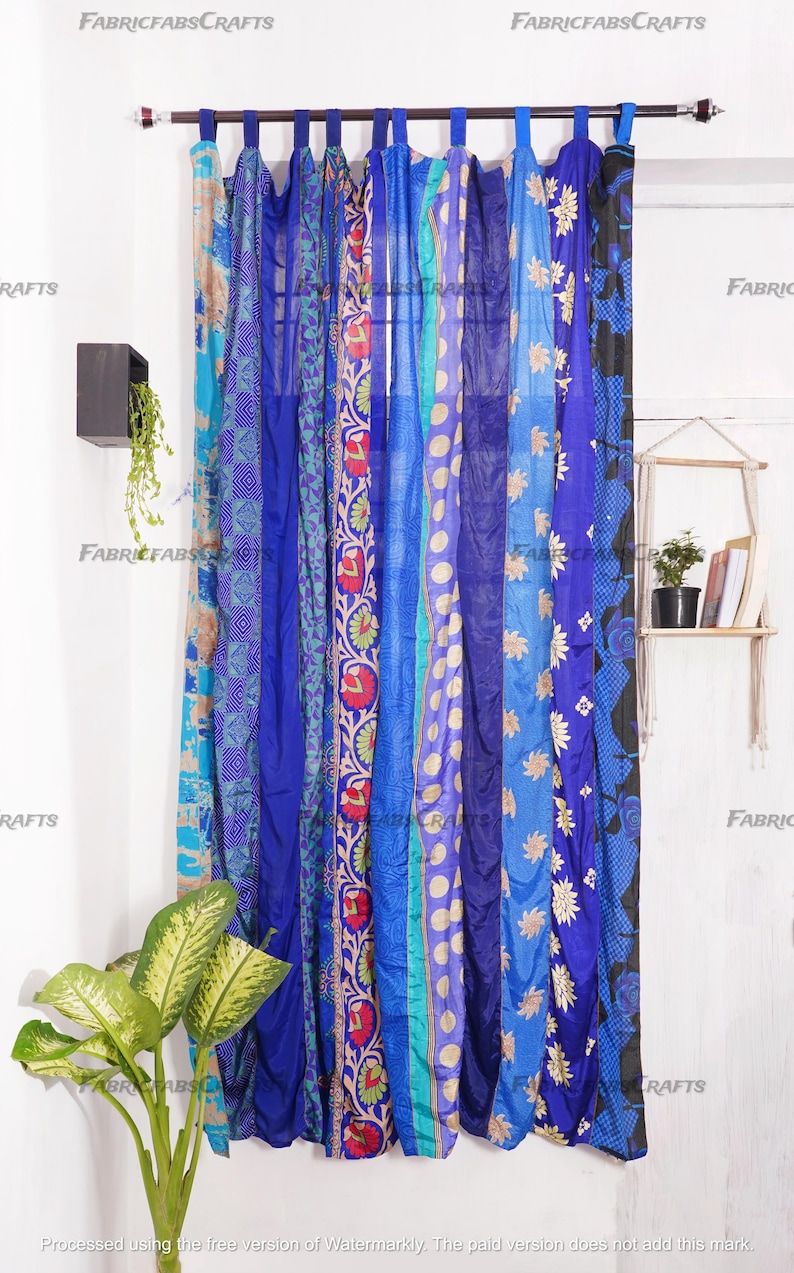 Puede incluir: Un conjunto de cortinas de tela con estampado azul y turquesa que cuelgan de una barra de cortina. Las cortinas est&aacute;n hechas de saris reciclados y tienen un estilo bohemio.