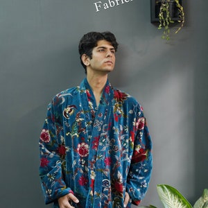 May include: A teal velvet robe with a floral pattern in red, white, and green. The robe has long sleeves and a shawl collar. The text "Fabricfabs Crafts" is visible in the image.