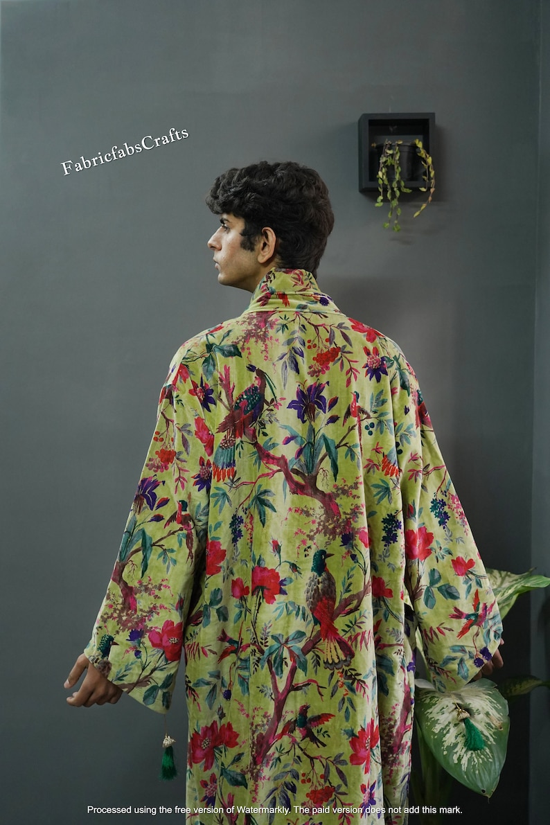 May include: A green velvet robe with a floral and bird print. The robe has a high collar and long sleeves. The fabric is soft and luxurious.