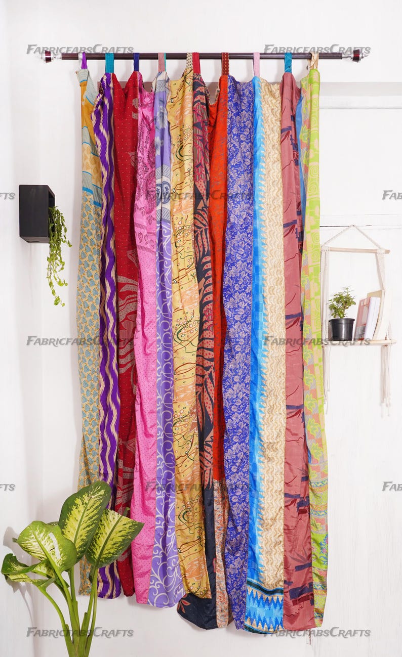Puede incluir: Una cortina colorida hecha de saris reutilizados, con una variedad de patrones y colores, incluyendo morado, rosa, azul, rojo, amarillo y verde. La cortina est&aacute; colgada de una barra y tiene aproximadamente 2,7 metros de largo.