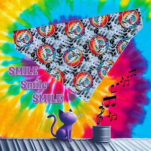 May include: A tie-dye background with a purple cat figurine and musical notes. A white bandana with a repeating colorful skull design is in the upper portion of the image. The word "SMILE" is written in purple.