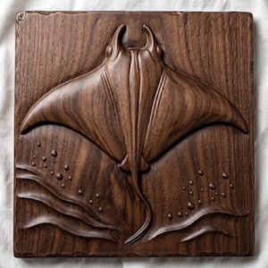 May include: A dark brown, square wooden relief carving of a manta ray. The ray is depicted with detailed wings and a long tail, set against a background of stylized waves and bubbles. The text "Manta Ray Ocean Relief Slab (daily.1007)" is at the bottom.