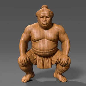 May include: A wooden sculpture of a sumo wrestler in a squatting pose. The figure is carved from light brown wood, with detailed musculature and traditional attire. The wrestler's face has a stern expression, and the sculpture is set against a grey background.